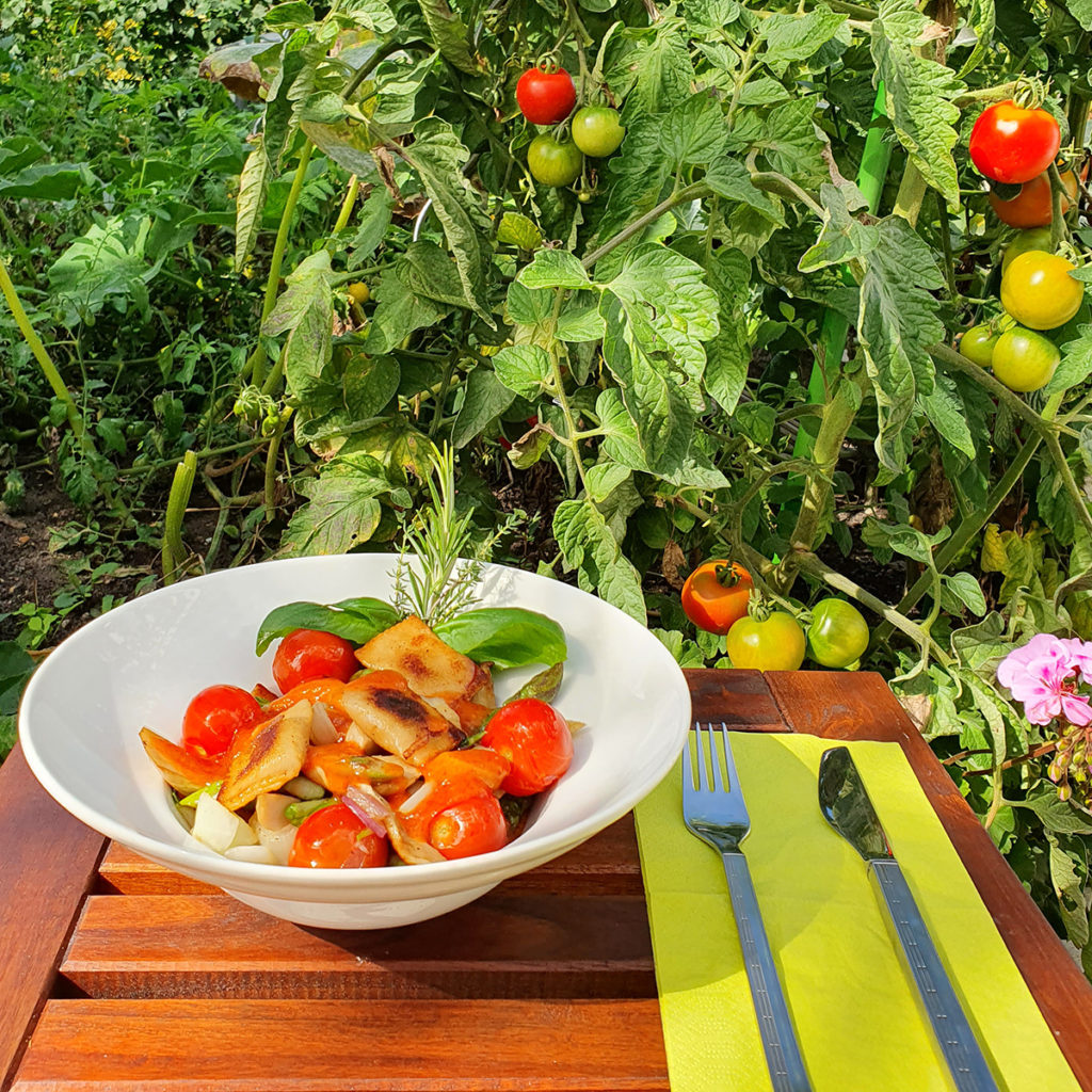 Gebratene Ravioli mit Gemüse und Kirschtomaten. 