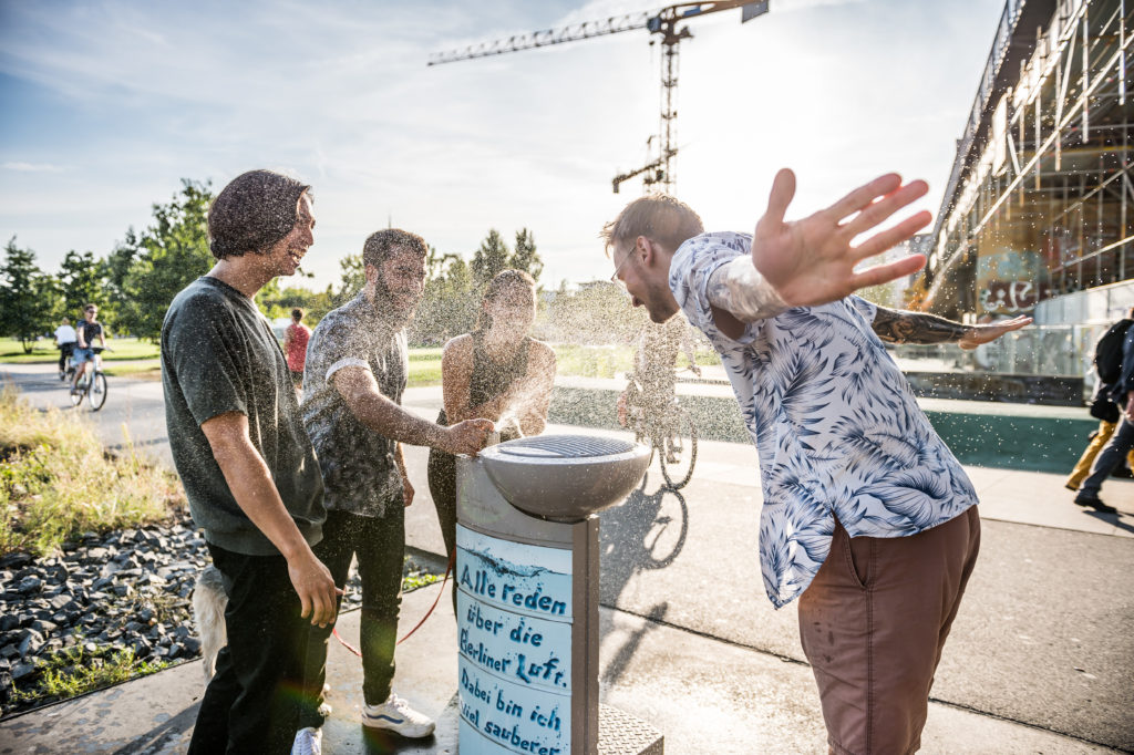 Gruppe von Menschen an einem Trinkwasserbrunnen