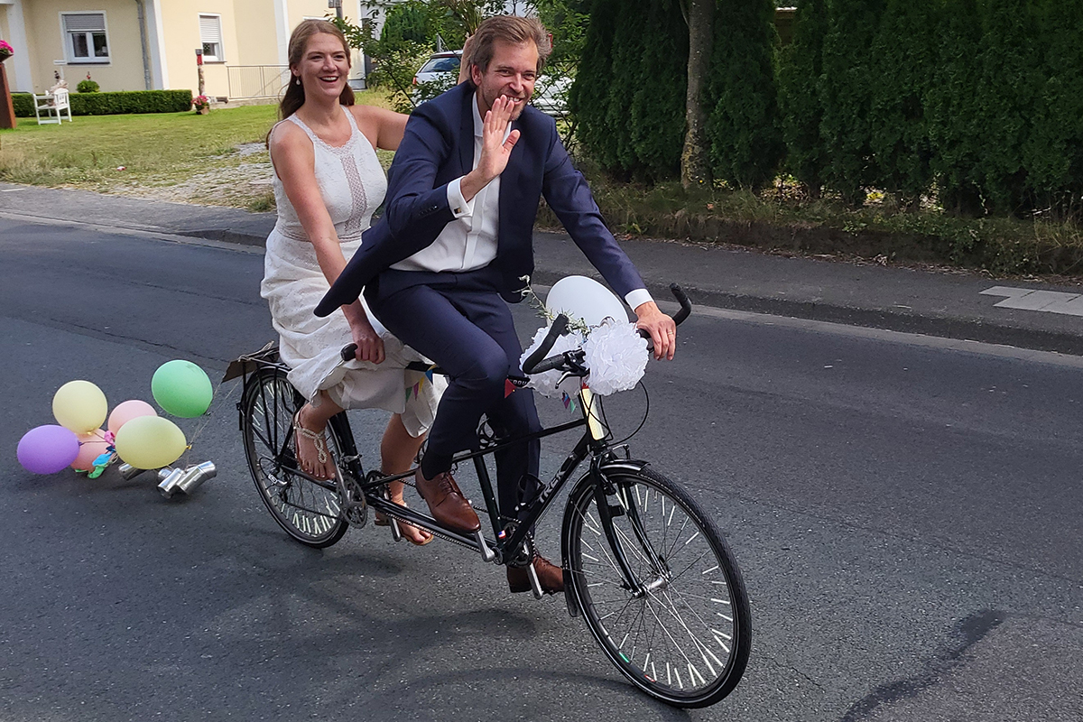 Brautpaar der vegetarischen Hochzeit auf einem Tandem