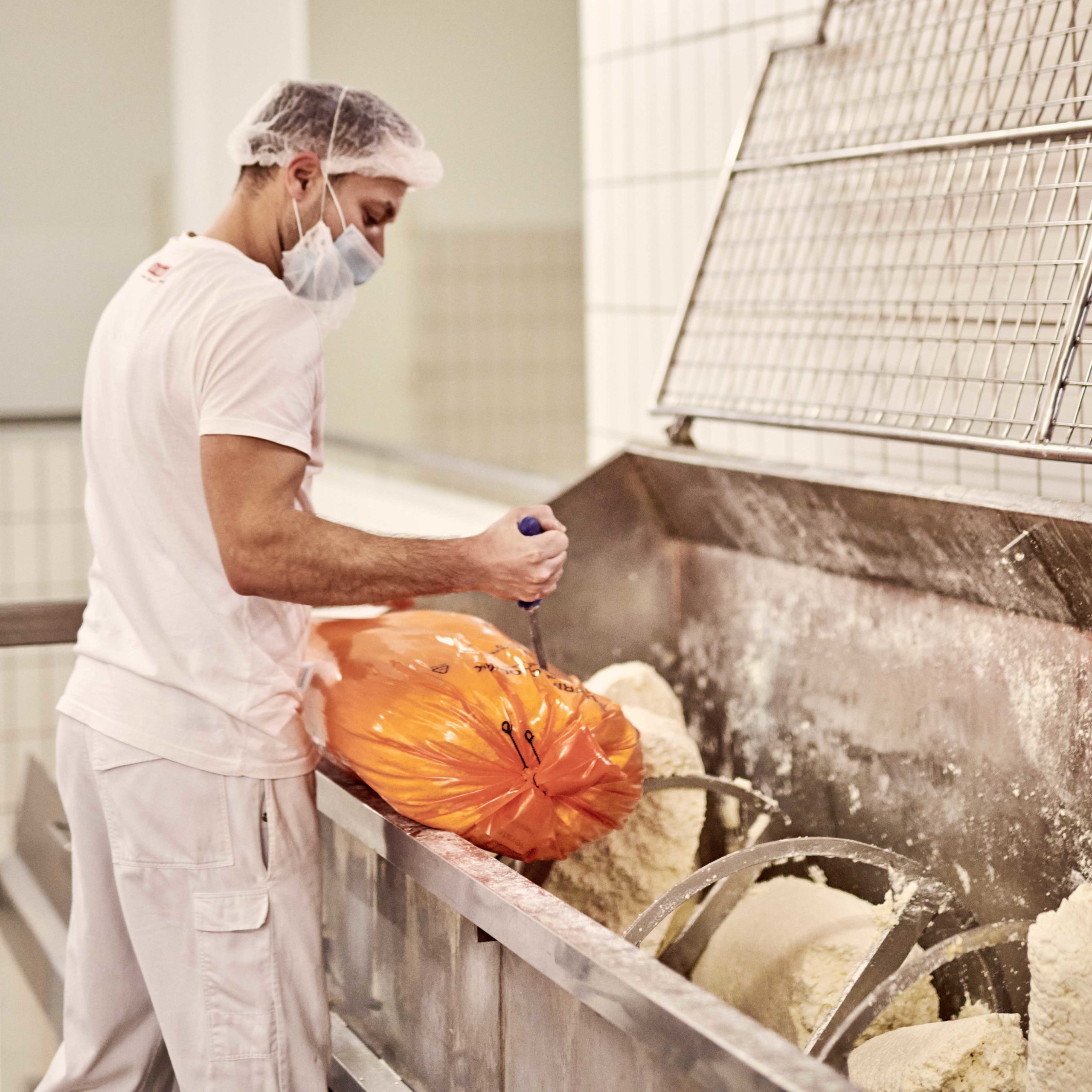 Sauermilchquark wird in einer Cutterwanne zur weiteren Verarbeitung vorbereitet.