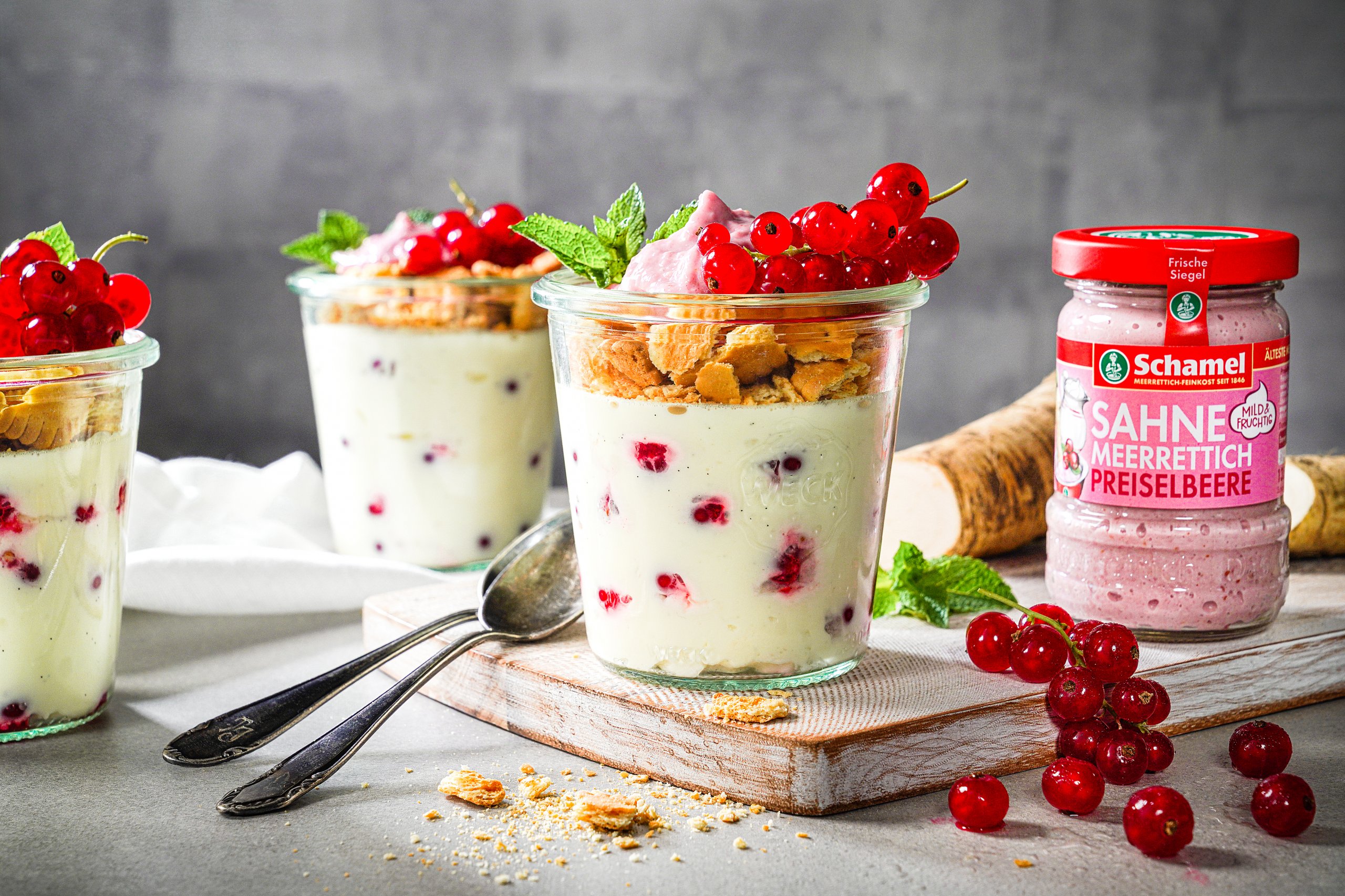 Drei Gläser Weißes Schokoladen-Panna-Cotta mit Johannisbeeren und Meerrettich und daneben ein Glas Sahne Meerrettich Preiselbeere von Schamel