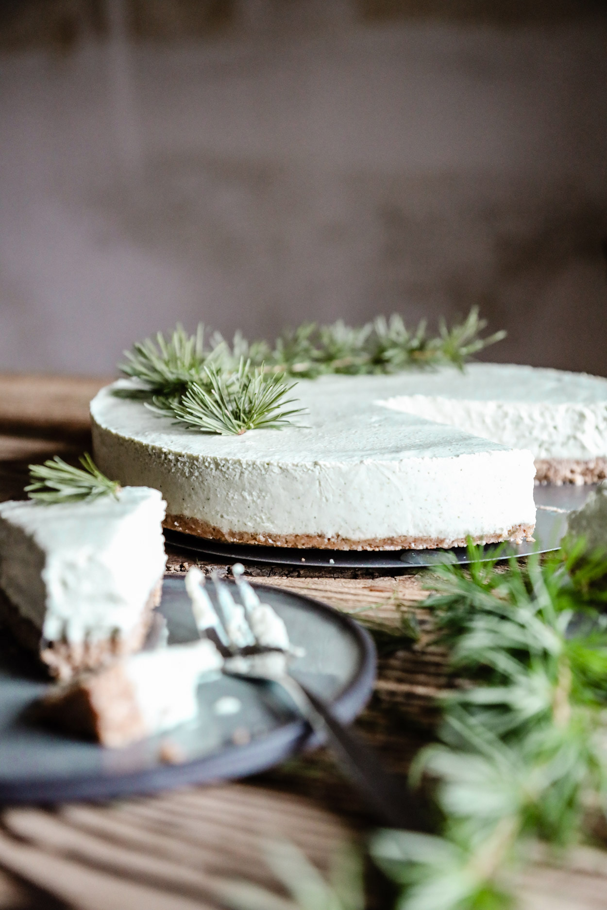 Ein angeschnittener Kuchen dekoriert mit Nadelzweigen.