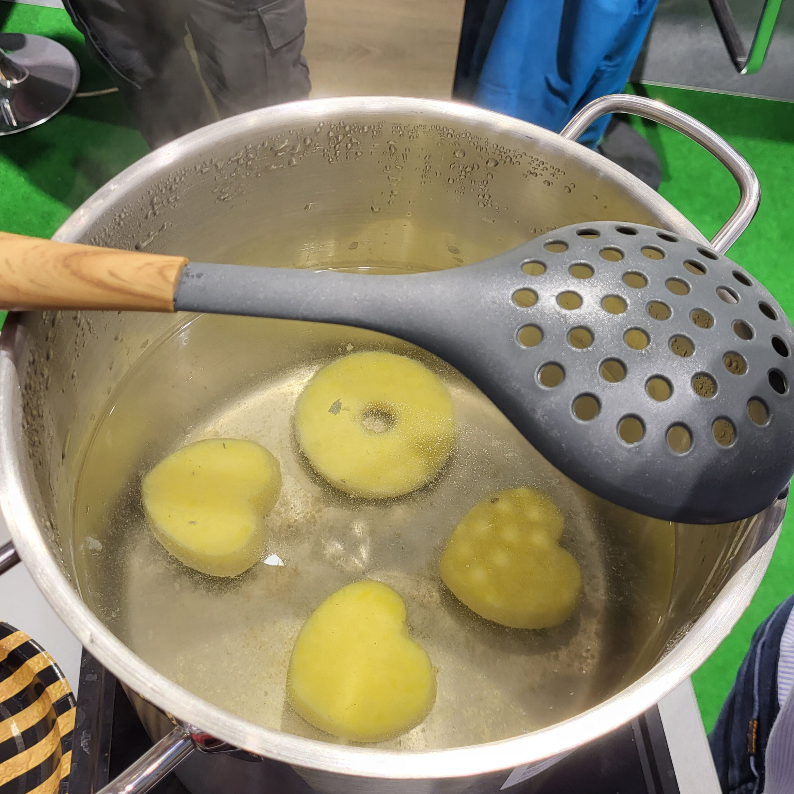 Thüringer Kloßdonuts kochen in einem Topf mit Wasser.