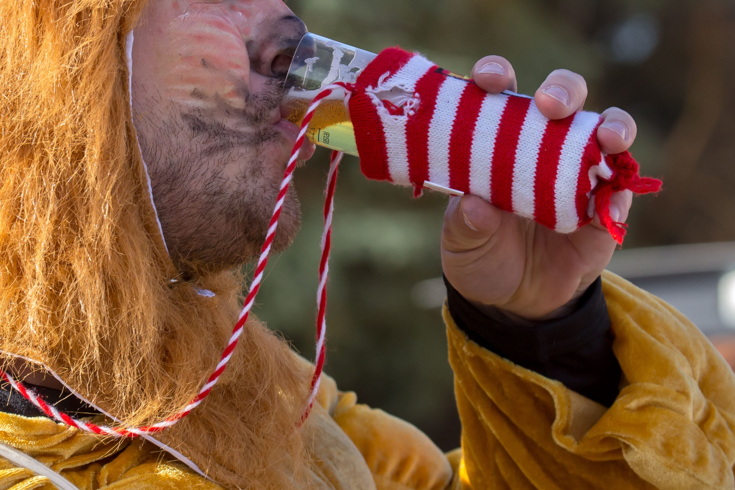 Ein Teilnehmer des Kölner Karneval trinkt ein Kölsch.