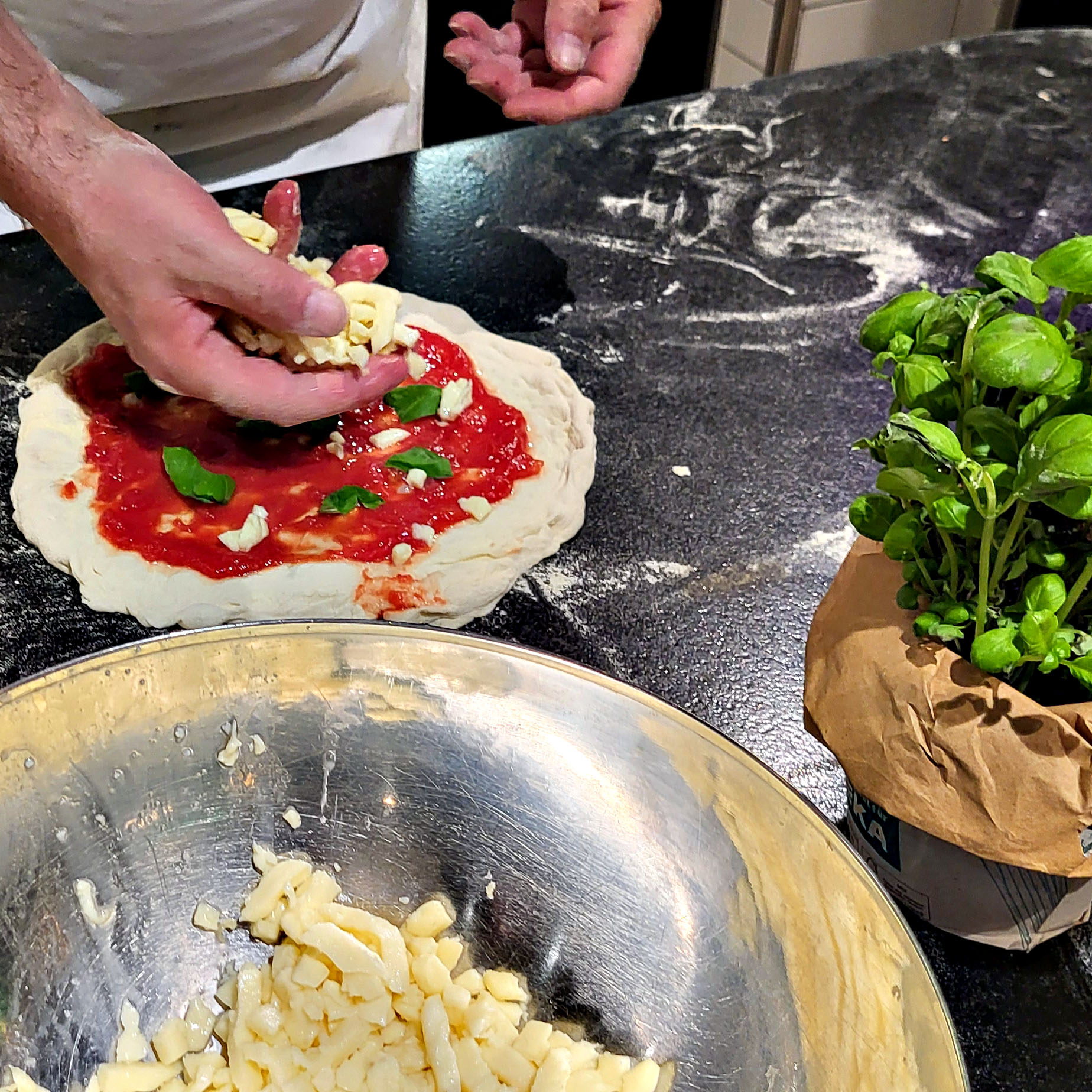 Der selbstgemachte Pizzateig wird belegt.