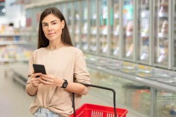 Frau im Supermarkt nutzt App Lebensmittelwarnung.de